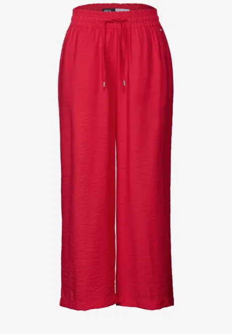 Weite, rote Hose mit Gummibund und Kordelzug.